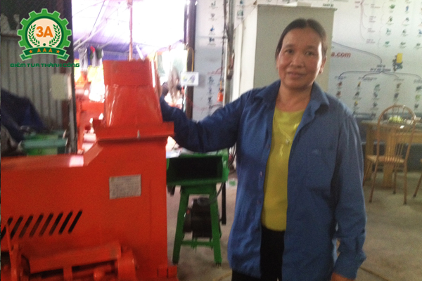 Cô Bùi Thị Ỏn bên cạnh chiếc máy băm cỏ 3A4Kw (3 pha)