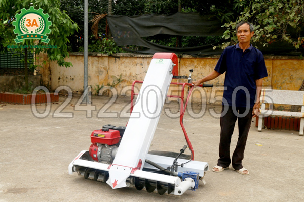 Chú Hùng bên cạnh chiếc máy hút thóc đóng bao 3A