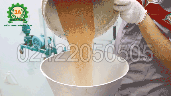 Đổ nguyên liệu vào phễu nạp liệu của máy ép cám viên trục đứng 3A7,5Kw