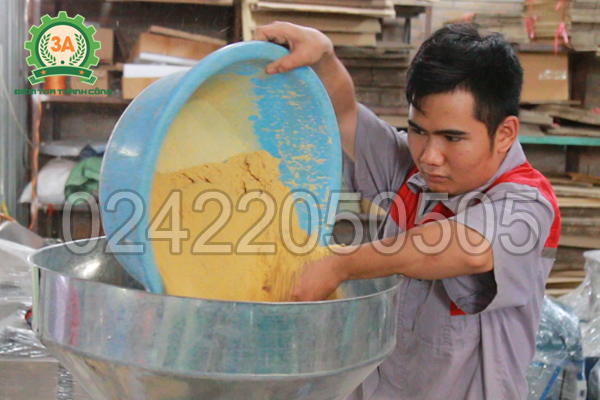 Đổ nguyên liệu vào phễu nạp của máy ép cám viên 3A30Kw