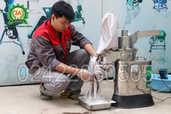 Kỹ thuật viên thu lấy bột sản phẩm đầu ra